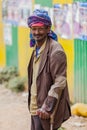 Old Arabic man using crutches and smiling at camera