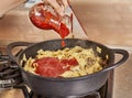 Adds tomato sauce to spaghetti with ground beef, fried in spaghetti bolognese pan according to recipe from the Internet Royalty Free Stock Photo