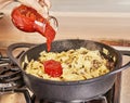 Adds tomato sauce to spaghetti with ground beef, fried in spaghetti bolognese pan according to recipe from the Internet Royalty Free Stock Photo