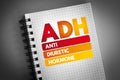 ADH - Antidiuretic Hormone acronym on notepad, concept background