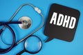 ADHD Attention Deficit Hyperactivity Disordertext with Stethoscope and magnifying glass on blue background Royalty Free Stock Photo