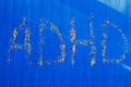 ADHD written with pastry sprinkles on a blue background. ADHD is Attention deficit hyperactivity disorder. Copyspace Royalty Free Stock Photo