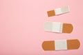 Adhesive bandage sticking plaster on pink background. Space for text Royalty Free Stock Photo