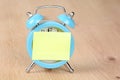 Adhesive note on a blue alarm clock Royalty Free Stock Photo
