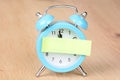 Adhesive note on a blue alarm clock Royalty Free Stock Photo