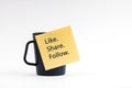 Adhesive note with Like Share Follow stick on coffee cup Royalty Free Stock Photo