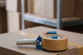 Adhesive tape dispenser on cardboard box indoors. Space for text Royalty Free Stock Photo