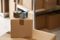 Adhesive tape dispenser on cardboard box indoors. Space for text Royalty Free Stock Photo