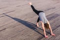 Adho Mukha Svanasana practiced by a young outdoor yoga enthusiast in the city