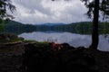 Adirondack Campfire on moody lake with Mountains in the background. Royalty Free Stock Photo