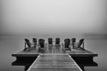 Adirondack deck chairs on lake dock Royalty Free Stock Photo