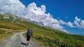 Adishi - A man hiking along a gravelled road in high Caucasus mountains in Georgia. The road leads to a ski resort on a slope Royalty Free Stock Photo