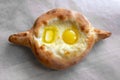 Adjara khachapuri - cheese pie with egg yolk and butter on paper