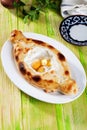 Adjara khachapuri three yolk quail eggs in still life on a plate green