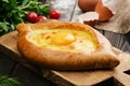 Adjarian khachapuri on wooden serving board. Georgian food. Caucasian.