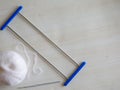Adjustable crochet fork for making lace, crocheting hook and woolen yarn ball on white wooden background