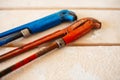 Adjustable gas wrenches of blue and red colour on wooden table Royalty Free Stock Photo