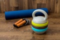 Adjustable kettlebell, jumping rope and mat for fitnes on wooden background. Weights for a fitness training.