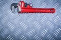 Adjustable monkey spanner on channeled metal background construc