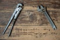 Adjustable and pipe wrenches on a wooden surface. Tool for car repair, plumbing. There is a copyspace. Selective focus,