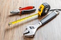 Adjustable pliers, Wrench and measuring tape on wooden table background. Working tools Royalty Free Stock Photo