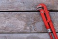 Adjustable red pipe wrench on wooden background. Royalty Free Stock Photo