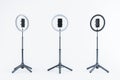 Adjustable ring lights with smartphone holders on tripods, isolated on a light background. 3D Rendering Royalty Free Stock Photo