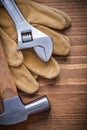 Adjustable spanner claw hammer protective gloves on wooden board Royalty Free Stock Photo