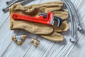 Adjustable spanner on leather gloves pipe fixtures water hoses on white wood boards