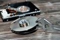 An adjustable spanner wrench and HDD platters together, hard disk drive disassembled damaged components, computer maintenance,