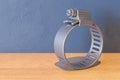 Adjustable Stainless Steel Worm Gear Hose Clamp on the wooden table. 3D rendering Royalty Free Stock Photo