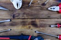 Adjustable water pump pliers, needle nose pliers locking pliers and screwdrivers on a wooden background. Top view Royalty Free Stock Photo