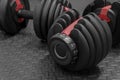 Adjustable weight dumbbell in plastic polymer material on black rubber