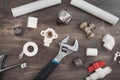 Adjustable wrench, plumbers tools and materials on the wooden background