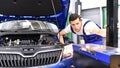 Adjusting the headlights on the car by mechanics in a garage