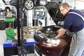 Adjusting the headlights on the car by mechanics in a garage