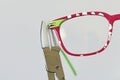 Adjusting inclination on patchy red and white children eyeglass frame. Royalty Free Stock Photo