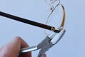 Adjusting inclination of temples on modern metal eyeglass frame with conical inclination pliers