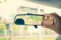 Adjusting the rearview mirror in the car to provide a better rear view for safe use of the car, Rearview mirror adjustment in cars Royalty Free Stock Photo