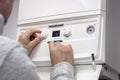 Adjusting thermostat setting on home heating system central heating boiler Royalty Free Stock Photo