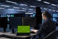 Admin in data center uses green screen laptop to update systems