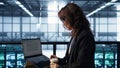 Woman in data center using laptop to update storage arrays, holding coffee cup Royalty Free Stock Photo