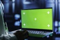 Admin runs code on green screen laptop