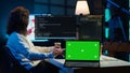Admin using green screen laptop to implement security measures