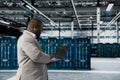 Admin walking in data center running lines of code on laptop Royalty Free Stock Photo