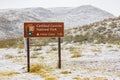 Admire the captivating beauty of the Carlsbad Caverns National Park sign amidst a blanket of snow on a winter day