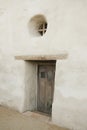 Adobe structure with a wood door and circular window Royalty Free Stock Photo