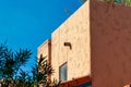 Adobe style orange cement building with front or back yard trees with clear blue sky background in neighborhood Royalty Free Stock Photo