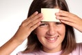 Adolescent face with a blank yellow sticky note Royalty Free Stock Photo