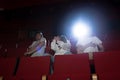 Adolescent friends watch a scary movie on the big screen Royalty Free Stock Photo